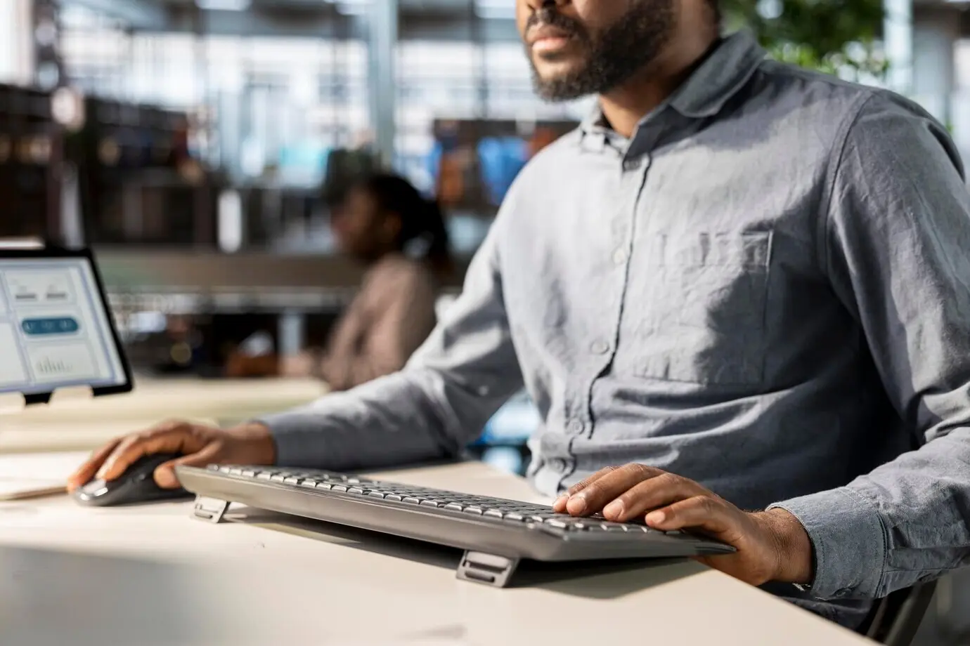 На рабочем месте бизнесмен анализирует на своем компьютере показатели эффективности.